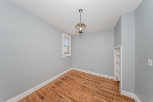 unfurnished room with baseboards and light wood-style floors