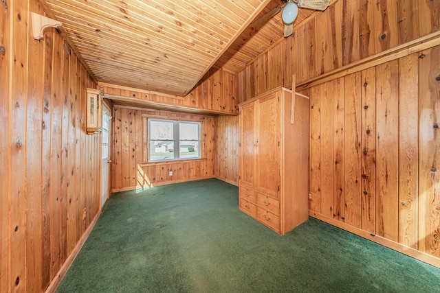 spare room featuring carpet flooring, lofted ceiling, wood walls, ceiling fan, and wooden ceiling
