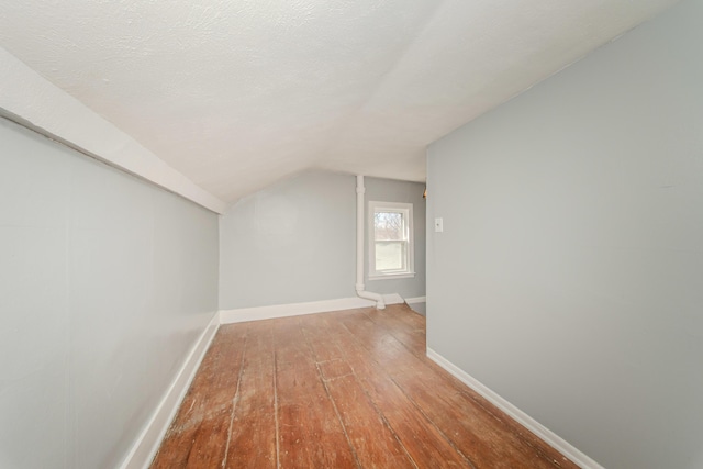 bonus room featuring vaulted ceiling, hardwood / wood-style floors, and baseboards