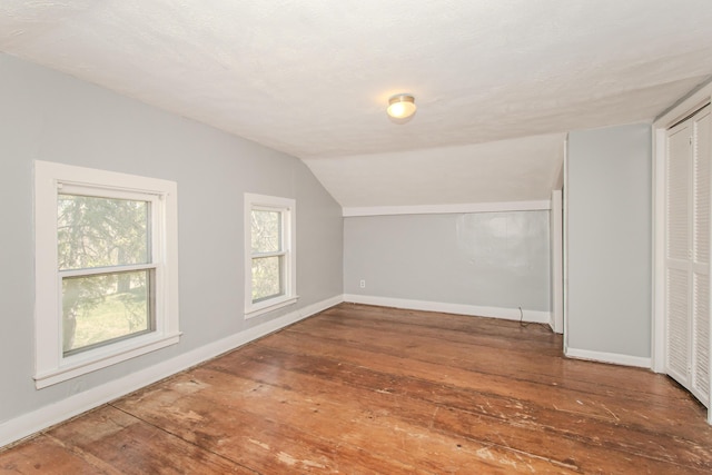 bonus room featuring vaulted ceiling, hardwood / wood-style floors, and baseboards