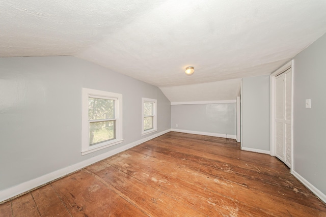 bonus room with vaulted ceiling, baseboards, and wood-type flooring