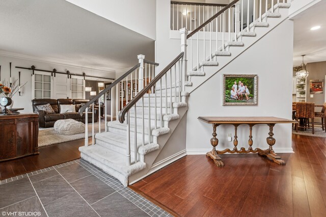 1888 Boardwalk, Saint Joseph, MI 49085 - stairs featuring a barn door, baseboards, recessed lighting, wood finished floors, and crown molding
