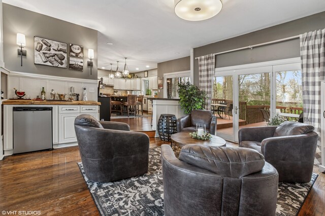 1888 Boardwalk, Saint Joseph, MI 49085 - living area featuring bar, an inviting chandelier, a healthy amount of sunlight, and dark wood-style floors