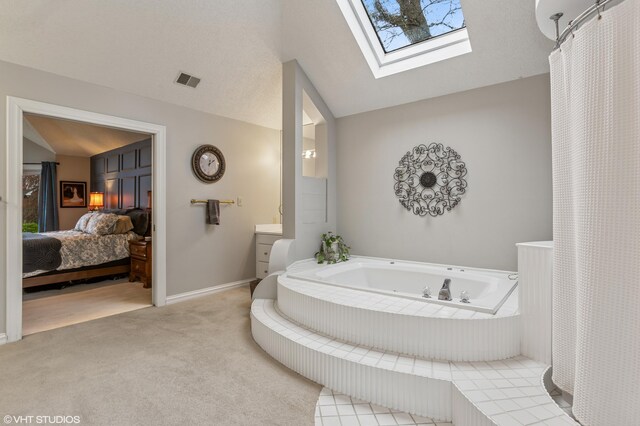 1888 Boardwalk, Saint Joseph, MI 49085 - bathroom featuring lofted ceiling with skylight, ensuite bathroom, baseboards, visible vents, and a whirlpool tub