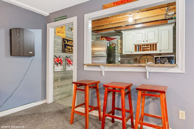 1888 Boardwalk, Saint Joseph, MI 49085 - interior space featuring carpet, baseboards, a kitchen bar, and freestanding refrigerator