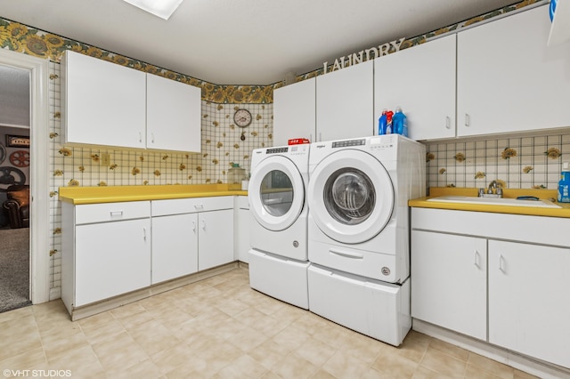 1888 Boardwalk, Saint Joseph, MI 49085 - laundry room with tile walls, washer and dryer, a sink, and cabinet space