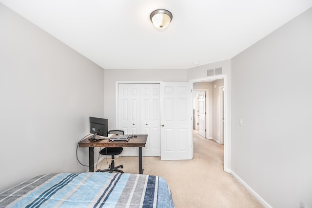 bedroom featuring light colored carpet, baseboards, visible vents, and a closet