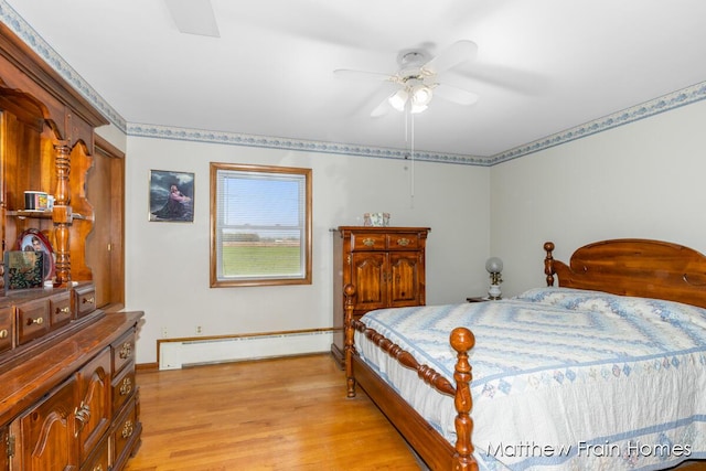 bedroom with light wood-type flooring, baseboard heating, baseboards, and a ceiling fan