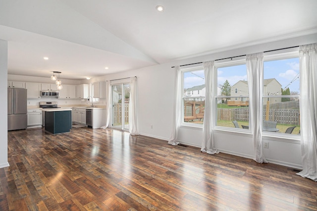 unfurnished living room with vaulted ceiling, a sink, dark wood-type flooring, and recessed lighting