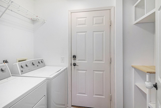 washroom with independent washer and dryer and laundry area