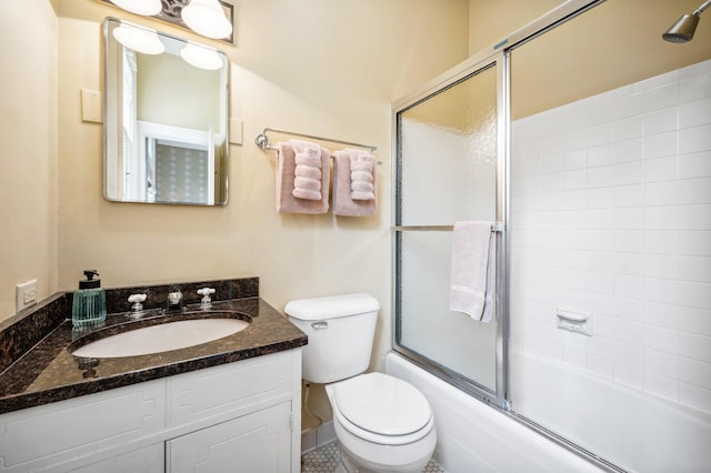 bathroom with toilet, vanity, and shower / bath combination with glass door