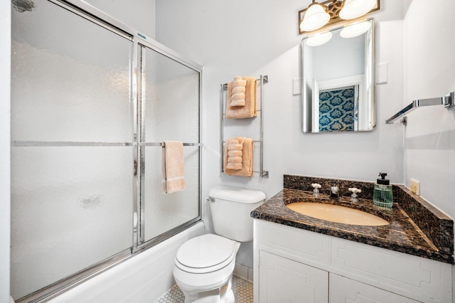 bathroom with vanity, bath / shower combo with glass door, and toilet
