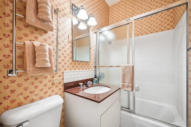 full bathroom with shower / bath combination with glass door, wallpapered walls, toilet, and vanity