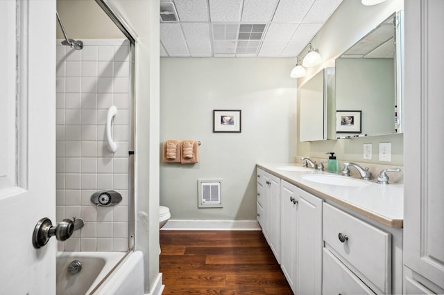 bathroom with double vanity, wood finished floors, baseboards, and a sink