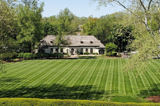 rear view of house featuring a lawn and a chimney