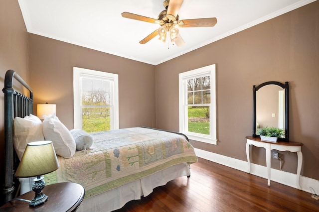 bedroom featuring wood finished floors, ornamental molding, baseboards, and multiple windows