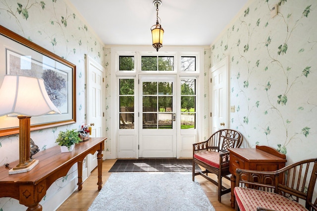 entryway with wood finished floors and wallpapered walls