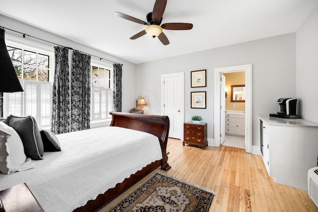 bedroom featuring connected bathroom, baseboards, a ceiling fan, and light wood-type flooring