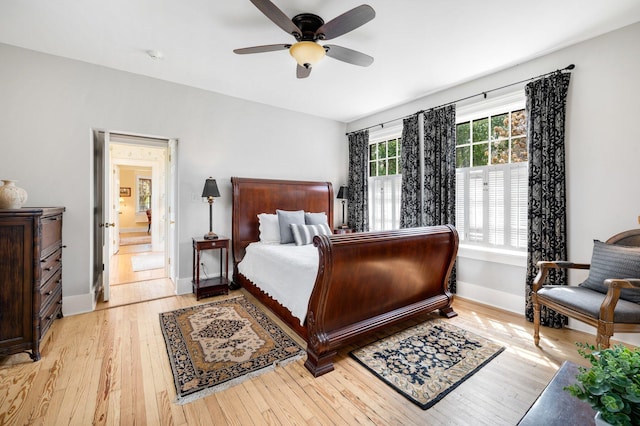 bedroom featuring connected bathroom, ceiling fan, baseboards, and light wood finished floors