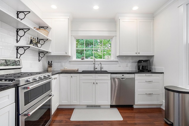 kitchen with dark countertops, appliances with stainless steel finishes, dark wood-style flooring, and a sink