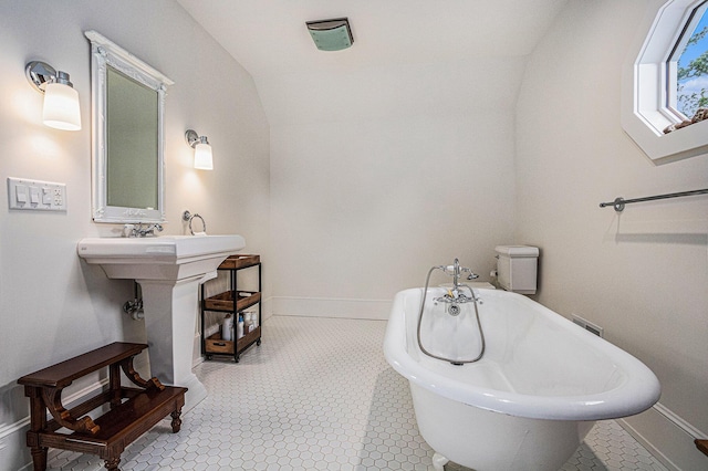 full bathroom featuring a freestanding tub and baseboards