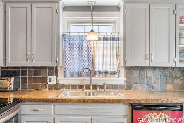 kitchen with dishwasher, a sink, white cabinetry, and decorative backsplash
