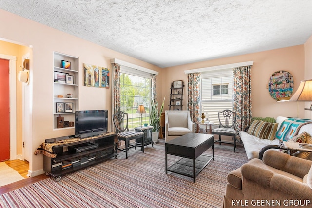 living room featuring a textured ceiling and built in shelves