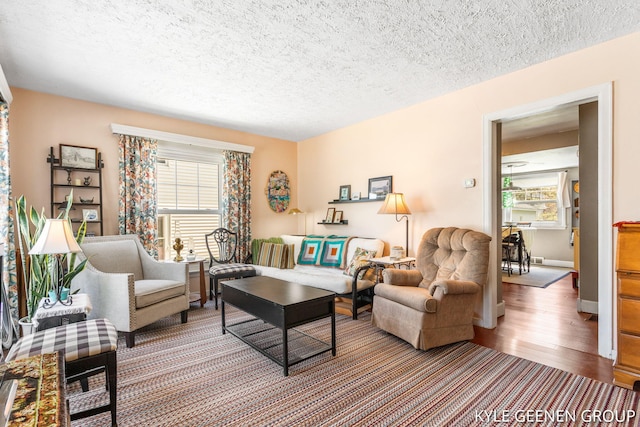 living area featuring plenty of natural light, wood finished floors, and a textured ceiling