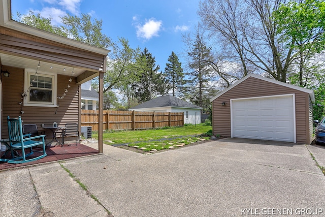 detached garage featuring fence and asphalt driveway