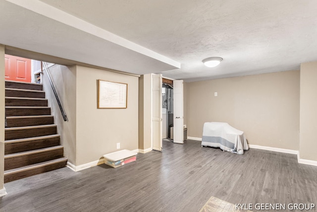 finished basement with baseboards, wood finished floors, and stairway