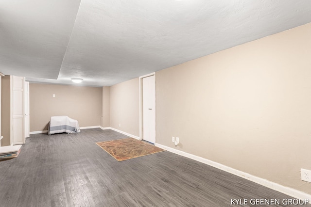finished below grade area featuring dark wood-style floors and baseboards