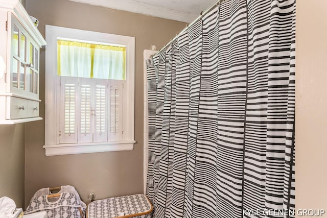 full bathroom featuring ornamental molding and a shower with curtain
