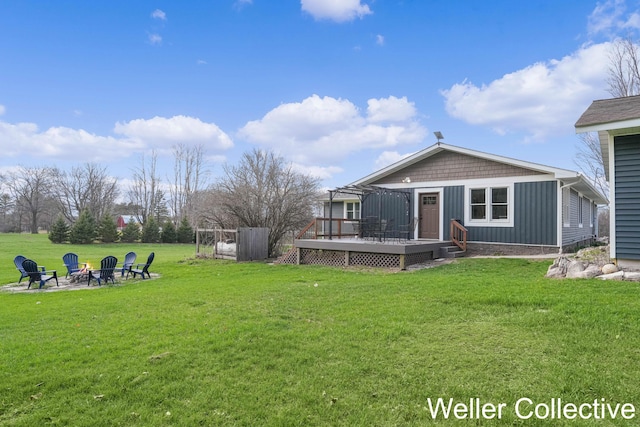 9090 E 32nd Rd, Cadillac, MI 49601 - back of house featuring board and batten siding, an outdoor fire pit, a wooden deck, and a yard