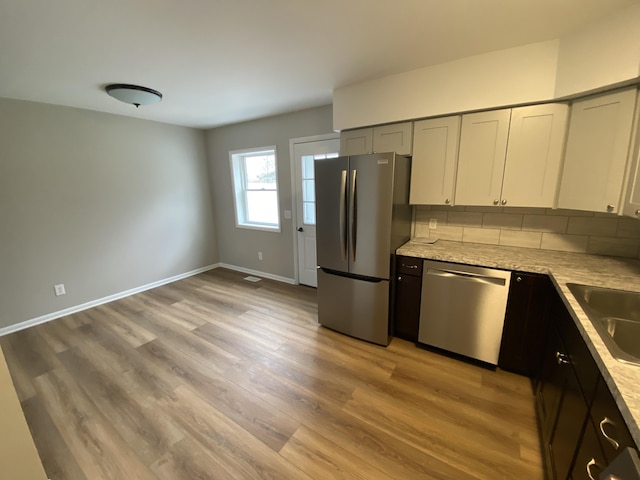 10 Meadow Hills Ln, Fremont, MI 49412 - kitchen featuring a sink, light wood finished floors, baseboards, appliances with stainless steel finishes, and light stone countertops