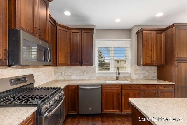 6501 Andres Xing Unit 14, Grandville, MI 49418 - kitchen with dark wood-style floors, stainless steel appliances, backsplash, a sink, and light stone countertops