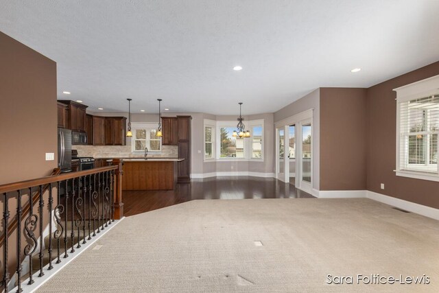 6501 Andres Xing Unit 14, Grandville, MI 49418 - kitchen with light countertops, freestanding refrigerator, baseboards, and a notable chandelier