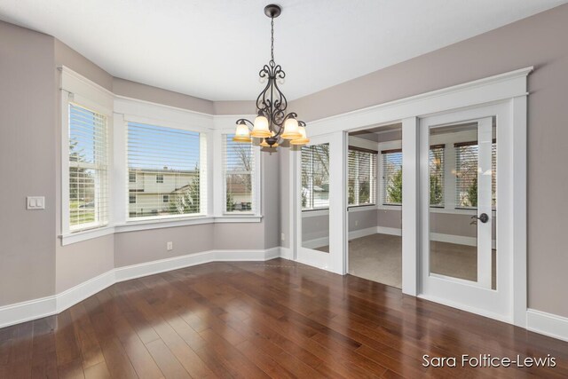 6501 Andres Xing Unit 14, Grandville, MI 49418 - unfurnished dining area featuring hardwood / wood-style floors, french doors, baseboards, and an inviting chandelier