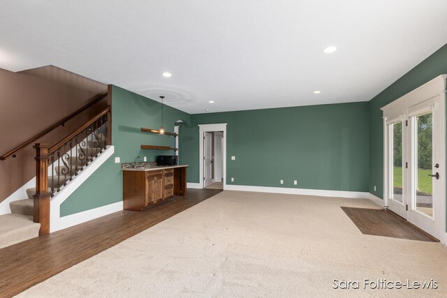 6501 Andres Xing Unit 14, Grandville, MI 49418 - unfurnished living room with indoor bar, baseboards, recessed lighting, dark carpet, and stairway