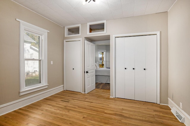 unfurnished bedroom featuring a closet, visible vents, and light wood finished floors