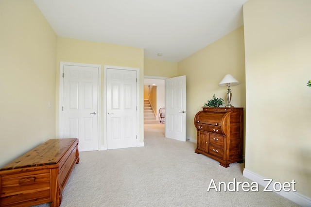bedroom with light carpet and baseboards