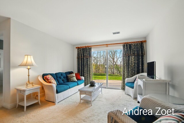 carpeted living area featuring visible vents and baseboards