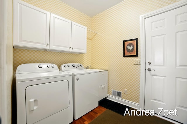 laundry room featuring dark wood finished floors, visible vents, wallpapered walls, and washing machine and dryer
