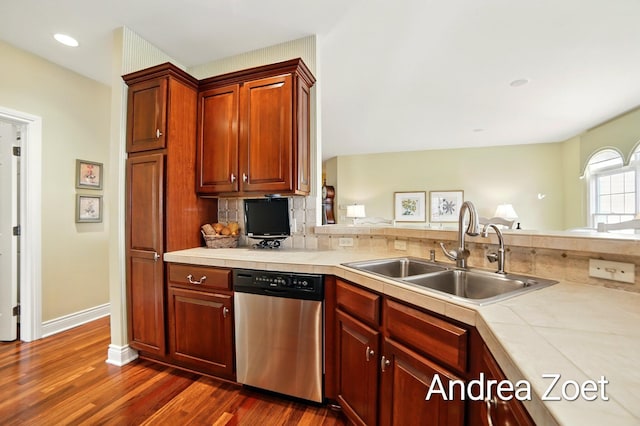 kitchen featuring decorative backsplash, stainless steel dishwasher, a sink, dark wood-style flooring, and recessed lighting