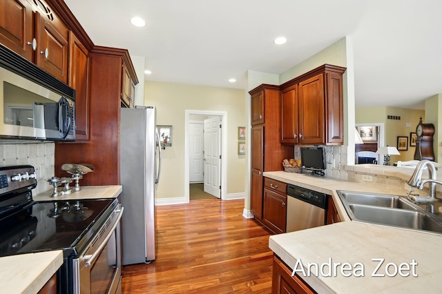 kitchen featuring backsplash, a sink, appliances with stainless steel finishes, and dark wood-type flooring