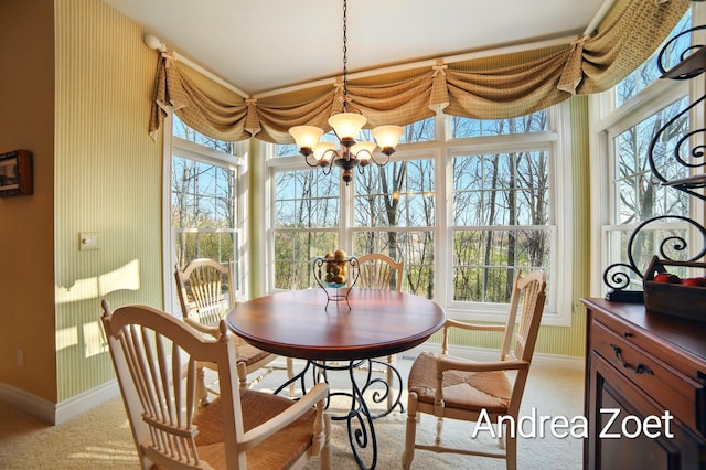 dining space featuring carpet flooring, a notable chandelier, a wealth of natural light, and baseboards