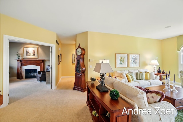 carpeted living area featuring a fireplace and baseboards