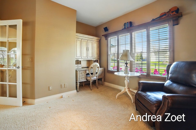 living area with baseboards, built in desk, and carpet flooring
