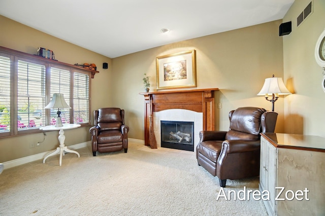 living area featuring a fireplace, visible vents, carpet flooring, and baseboards