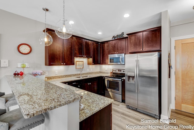 430 Union Ave NE Unit 303, Grand Rapids, MI 49503 - kitchen with a sink, light wood finished floors, a peninsula, appliances with stainless steel finishes, and light stone countertops