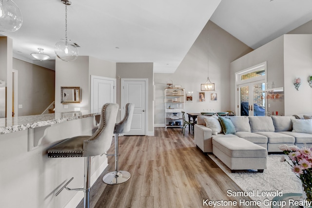 430 Union Ave NE Unit 303, Grand Rapids, MI 49503 - living room with high vaulted ceiling, stairs, light wood-style floors, and baseboards